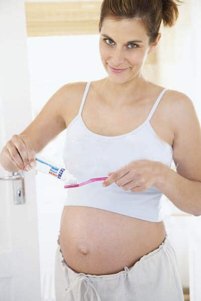 pregnant woman about to start brushing her teeth